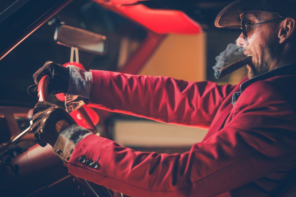 Happy Cowboy Millionaire in His 30s with Burning Cigar in the Vintage Classic Car. American Dream Come True. Lucky Jackpot Winner Leaving Las Vegas by duallogic