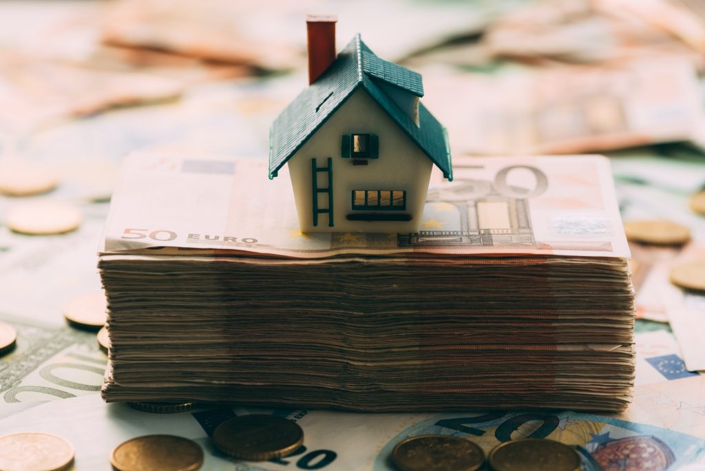 House model on cash stack closeup